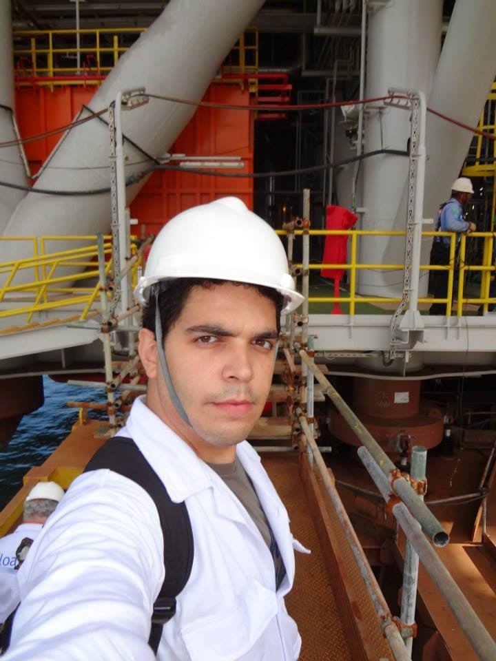 Profissional com capacete em ambiente industrial com tubulações e plataformas metálicas