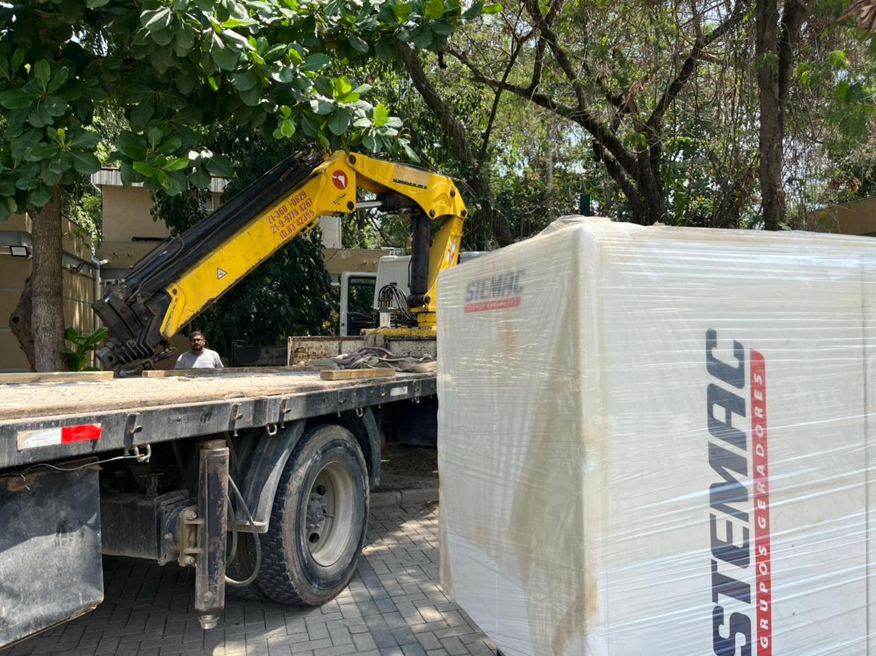 Grupo gerador junto a um caminhão equipado com guindaste